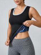 Person wearing a black athletic top and gray leggings on a plain background
