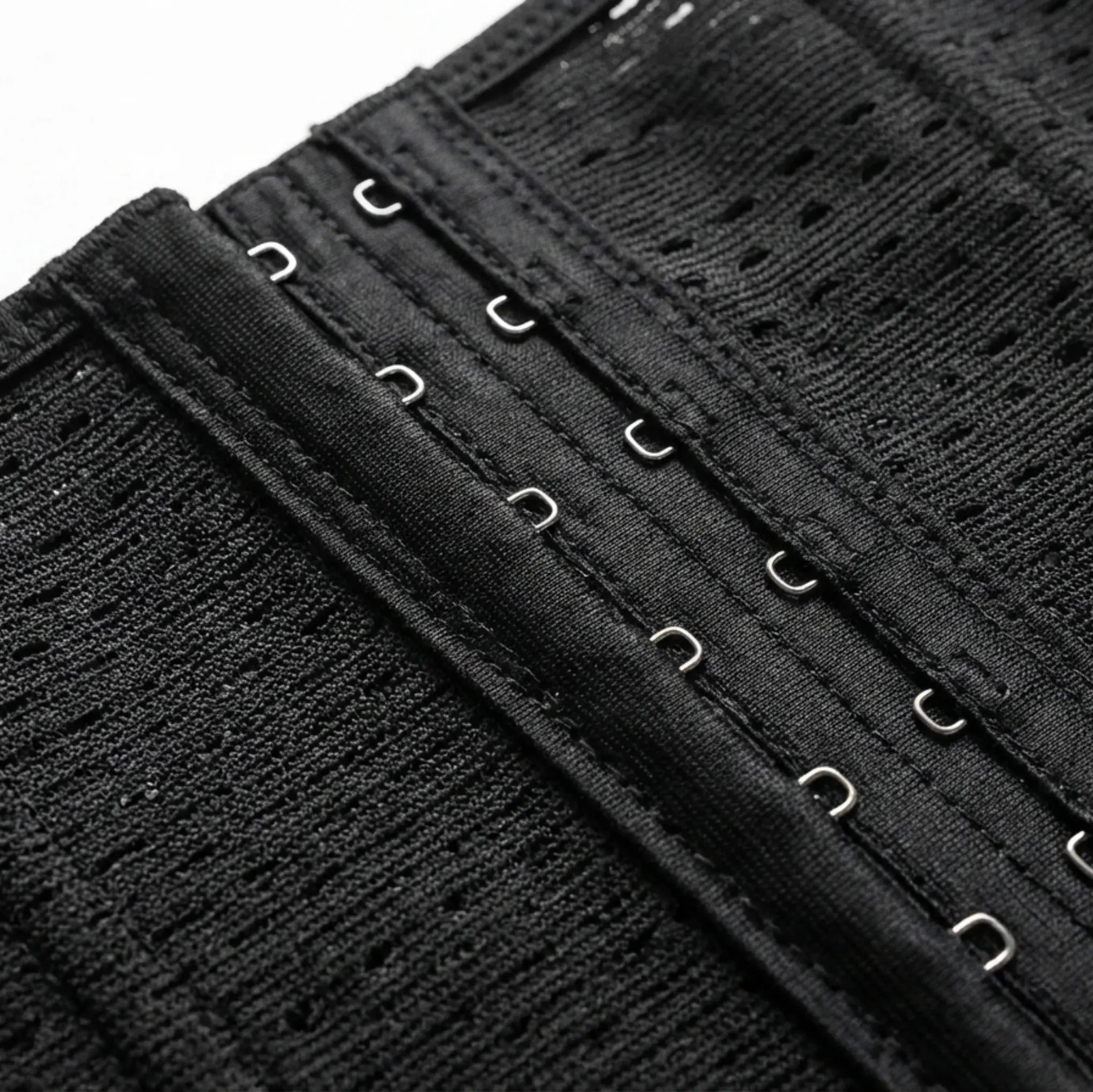 Close-up of a black waist trainer with hooks on a white background